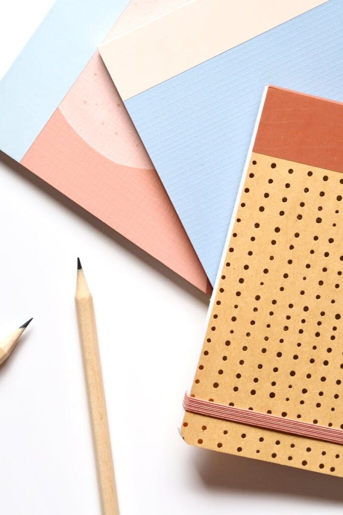 Colorful notebooks and pencils arranged neatly for a creative workspace.