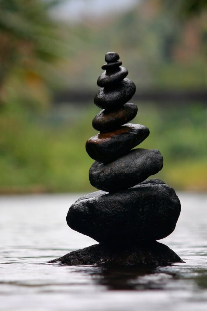 Balanced stones in a serene river evoke a sense of peace and tranquility.